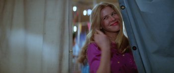 Movie still from “The Funhouse” (1981), directed by Tobe Hooper – A woman smiles while brushing her blonde hair; Medium shot, Over the shoulder angle