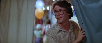 Movie still from “The Funhouse” (1981), directed by Tobe Hooper – A young man wearing glasses and a plaid shirt; Medium shot, Over the shoulder angle