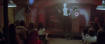 Movie still from “The Funhouse” (1981), directed by Tobe Hooper – Two girls watching a clown on a stage; Wide shot, Over the shoulder angle