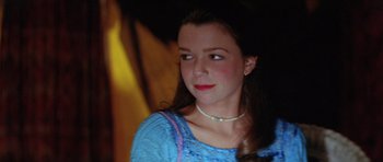 Movie still from “The Funhouse” (1981), directed by Tobe Hooper – A young woman wearing a blue shirt and a necklace; Close Up shot, Over the shoulder angle