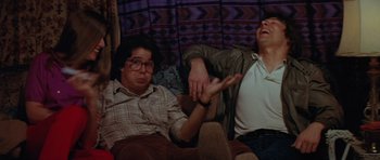 Movie still from “The Funhouse” (1981), directed by Tobe Hooper – Two men sitting on a couch with their arms outstreched; Medium shot, Low angle