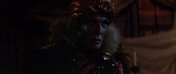 Movie still from “The Funhouse” (1981), directed by Tobe Hooper – A man in a pirate hat and a wig looking at the camera; Close Up shot, Over the shoulder angle