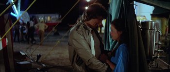 Movie still from “The Funhouse” (1981), directed by Tobe Hooper – A man and a woman standing next to each other; Medium shot, Over the shoulder angle