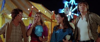 Movie still from “The Funhouse” (1981), directed by Tobe Hooper – Two young women standing next to each other at an amusement park at night; Medium shot, Over the shoulder angle