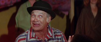 Movie still from “The Funhouse” (1981), directed by Tobe Hooper – An older man wearing a black hat and a striped shirt; Close Up shot, Low angle