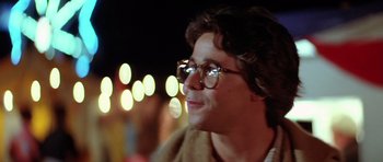 Movie still from “The Funhouse” (1981), directed by Tobe Hooper – A person wearing glasses with lights in the background; Close Up shot, Over the shoulder angle
