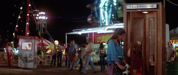 Movie still from “The Funhouse” (1981), directed by Tobe Hooper – A group of people walking around a carnival; Medium shot, Over the shoulder angle