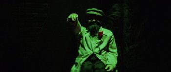 Movie still from “The Funhouse” (1981), directed by Tobe Hooper – A man with a beard and a hat is holding a rose; Medium shot, High angle