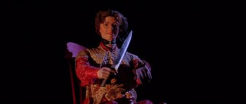 Movie still from “The Funhouse” (1981), directed by Tobe Hooper – A person holding a knife in a dark room; Medium shot, Low angle