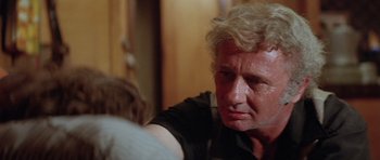 Movie still from “The Funhouse” (1981), directed by Tobe Hooper – An older man sitting in a room with his eyes closed; Close Up shot, Over the shoulder angle