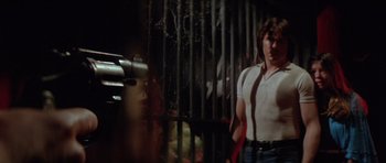 Movie still from “The Funhouse” (1981), directed by Tobe Hooper – A man standing in front of a metal fence; Medium shot, Low angle
