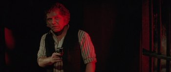 Movie still from “The Funhouse” (1981), directed by Tobe Hooper – A man holding a cell phone in a dark room; Close Up shot, Low angle