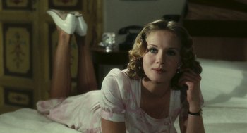 Movie still from “The Garden of the Finzi-Continis” (1970), directed by Vittorio De Sica – A woman in a pink dress sitting on a bed; Close Up shot, High angle