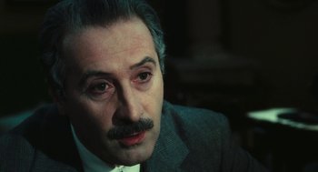 Movie still from “The Garden of the Finzi-Continis” (1970), directed by Vittorio De Sica – A person wearing a suit and tie; Close Up shot, High angle