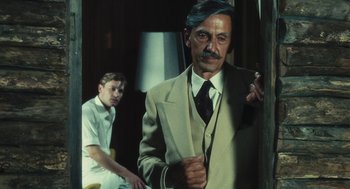 Movie still from “The Garden of the Finzi-Continis” (1970), directed by Vittorio De Sica – A man in a suit standing next to another man in a tie; Medium shot, Over the shoulder angle