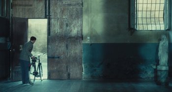 Movie still from “The Garden of the Finzi-Continis” (1970), directed by Vittorio De Sica – A bicycle parked in front of an open door; Wide shot, Over the shoulder angle