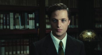 Movie still from “The Garden of the Finzi-Continis” (1970), directed by Vittorio De Sica – A man in a suit and tie in front of a bookshelf; Close Up shot, Low angle