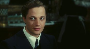 Movie still from “The Garden of the Finzi-Continis” (1970), directed by Vittorio De Sica – A man wearing a suit and tie; Close Up shot, Over the shoulder angle