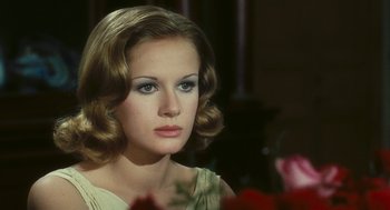 Movie still from “The Garden of the Finzi-Continis” (1970), directed by Vittorio De Sica – A beautiful woman with long brown hair wearing a white dress; Close Up shot, Over the shoulder angle