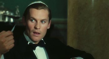 Movie still from “The Garden of the Finzi-Continis” (1970), directed by Vittorio De Sica – A person wearing a suit and tie; Close Up shot, Over the shoulder angle