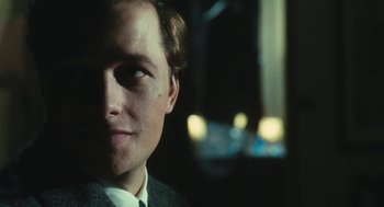 Movie still from “The Garden of the Finzi-Continis” (1970), directed by Vittorio De Sica – A person wearing a suit and tie; Close Up shot, Over the shoulder angle