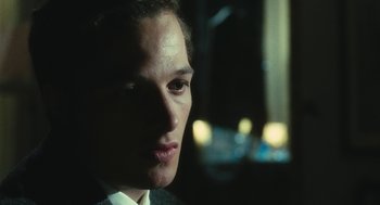 Movie still from “The Garden of the Finzi-Continis” (1970), directed by Vittorio De Sica – A person wearing a suit and tie; Close Up shot, Over the shoulder angle