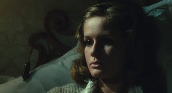 Movie still from “The Garden of the Finzi-Continis” (1970), directed by Vittorio De Sica – A woman sitting on a bed looking at the camera; Close Up shot, High angle