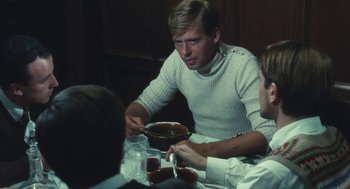 Movie still from “The Garden of the Finzi-Continis” (1970), directed by Vittorio De Sica – Two men sitting at a table with a bowl of soup in front of them; Medium shot, Over the shoulder angle