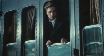Movie still from “The Garden of the Finzi-Continis” (1970), directed by Vittorio De Sica – A man in a suit is looking out of a train window; Medium shot, Over the shoulder angle