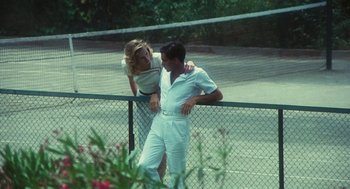 Movie still from “The Garden of the Finzi-Continis” (1970), directed by Vittorio De Sica – A man and a woman standing next to each other on a tennis court; Medium shot, Low angle