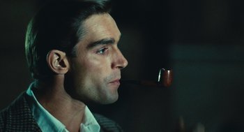 Movie still from “The Garden of the Finzi-Continis” (1970), directed by Vittorio De Sica – A person with a pipe in his mouth; Close Up shot, Over the shoulder angle