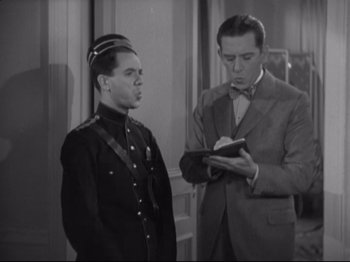 Movie still from “The Gay Divorcee” (1934), directed by Mark Sandrich – Two men in uniform looking at a book; Medium shot, High angle