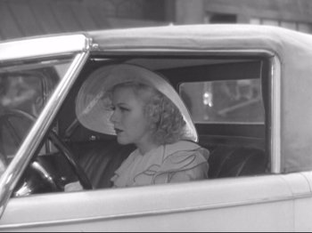 Movie still from “The Gay Divorcee” (1934), directed by Mark Sandrich – A black and white photo of a woman driving a car; Medium shot, High angle