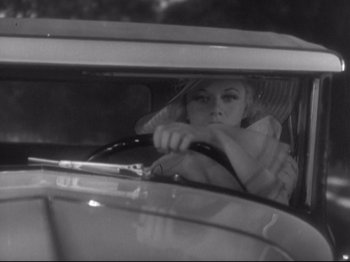 Movie still from “The Gay Divorcee” (1934), directed by Mark Sandrich – A black and white photo of a woman driving a car; Medium shot, High angle