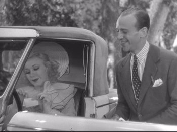 Movie still from “The Gay Divorcee” (1934), directed by Mark Sandrich – A man and a woman sitting in the back of a car; Medium shot, Over the shoulder angle