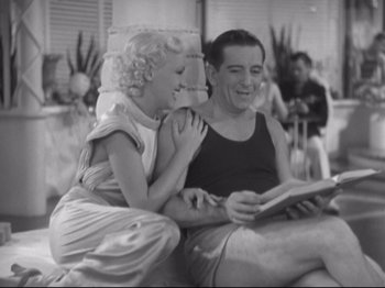 Movie still from “The Gay Divorcee” (1934), directed by Mark Sandrich – A man and a woman sitting next to each other on a couch; Medium shot, High angle
