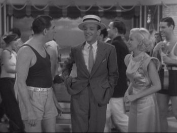 Movie still from “The Gay Divorcee” (1934), directed by Mark Sandrich – A group of people standing next to each other in a room; Medium shot, Over the shoulder angle