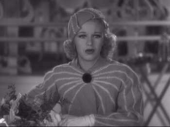 Movie still from “The Gay Divorcee” (1934), directed by Mark Sandrich – A black - and - white photo of a woman holding flowers; Close Up shot, High angle