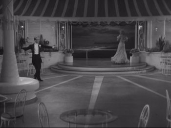 Movie still from “The Gay Divorcee” (1934), directed by Mark Sandrich – A man and a woman are dancing in front of a stage; Wide shot, High angle