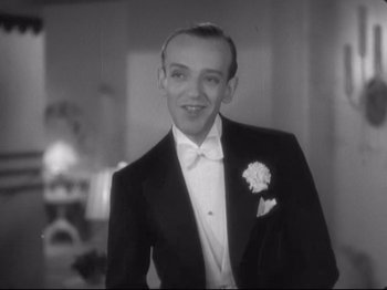 Movie still from “The Gay Divorcee” (1934), directed by Mark Sandrich – A man in a tuxedo with a flower in his lapel; Close Up shot, Low angle