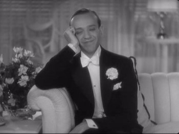 Movie still from “The Gay Divorcee” (1934), directed by Mark Sandrich – A man in a tuxedo sitting on a couch; Close Up shot, High angle