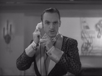 Movie still from “The Gay Divorcee” (1934), directed by Mark Sandrich – A black and white photo of a man adjusting his tie; Close Up shot, Low angle