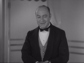 Movie still from “The Gay Divorcee” (1934), directed by Mark Sandrich – An old photo of a man in a suit and bow tie; Medium shot, Low angle