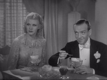 Movie still from “The Gay Divorcee” (1934), directed by Mark Sandrich – A man and a woman sitting at a dinner table; Medium shot, High angle