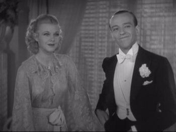 Movie still from “The Gay Divorcee” (1934), directed by Mark Sandrich – A man and a woman posing for a picture in formal wear; Medium shot, Low angle