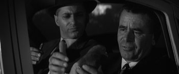 Movie still from “The Gazebo” (1959), directed by George Marshall – A man in a suit and tie holding a stuffed animal; Close Up shot, Over the shoulder angle