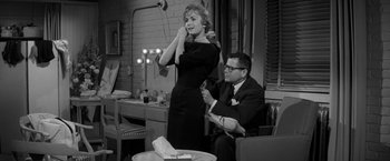 Movie still from “The Gazebo” (1959), directed by George Marshall – A man and a woman are sitting in front of a table; Medium shot, Over the shoulder angle