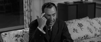 Movie still from “The Gazebo” (1959), directed by George Marshall – An older man talking on a cell phone while sitting at a table; Close Up shot, High angle
