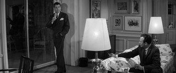 Movie still from “The Gazebo” (1959), directed by George Marshall – A black and white photo of a man and a woman in a bedroom; Wide shot, Over the shoulder angle