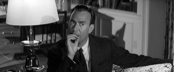 Movie still from “The Gazebo” (1959), directed by George Marshall – A man in a suit and tie is holding his finger in his mouth; Close Up shot, Over the shoulder angle